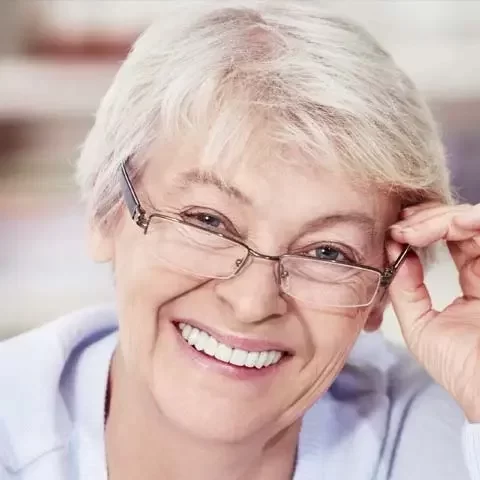 Senior woman smiling adjusting glasses